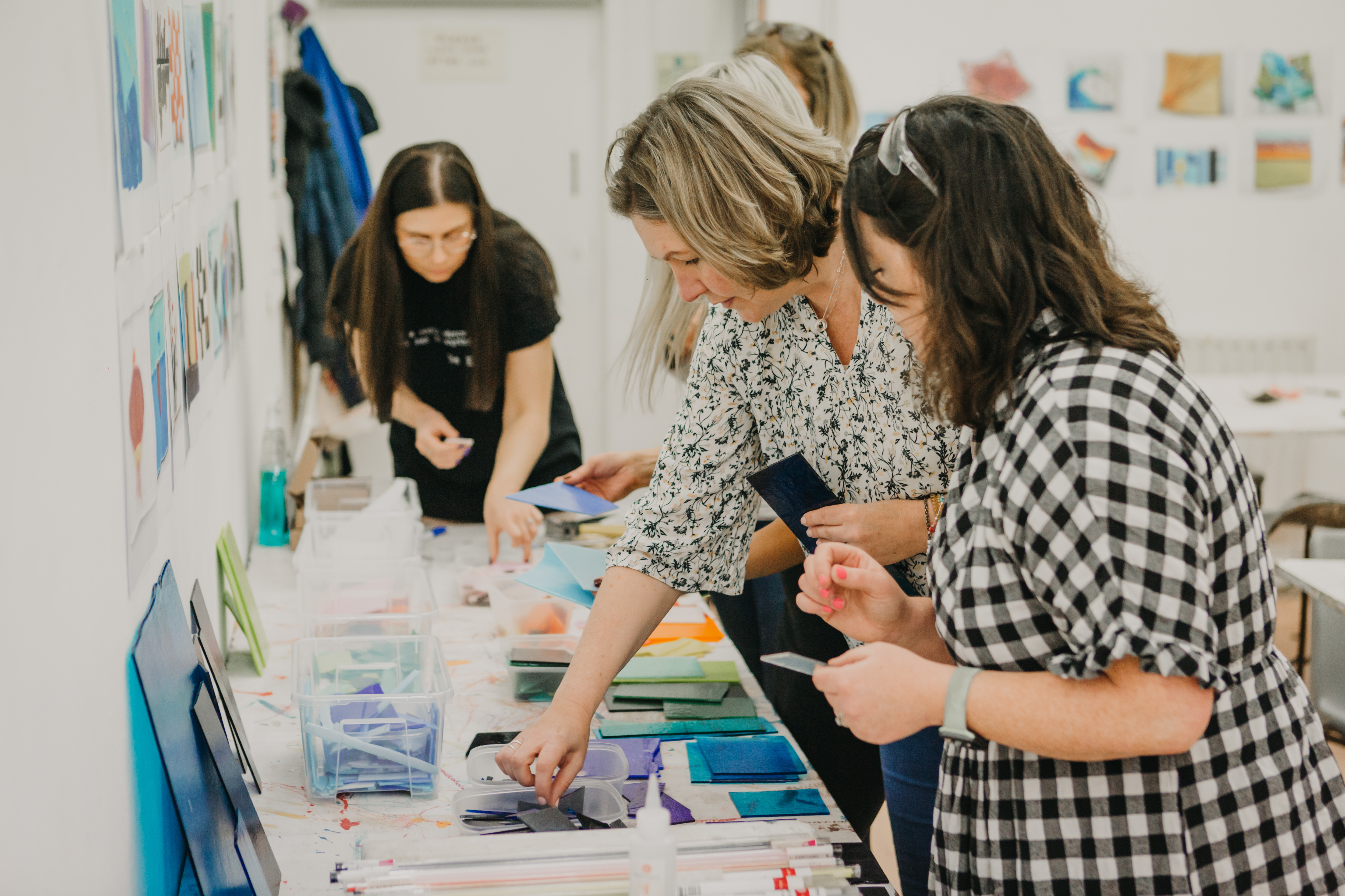 A group of four women selecting coloured glass for a glass fusing project